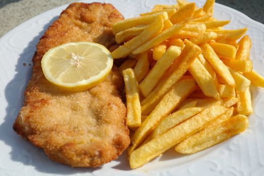 Schnitzel mit Pommes und Zitrone von Bon Appetit Bockfließ auf einem Teller